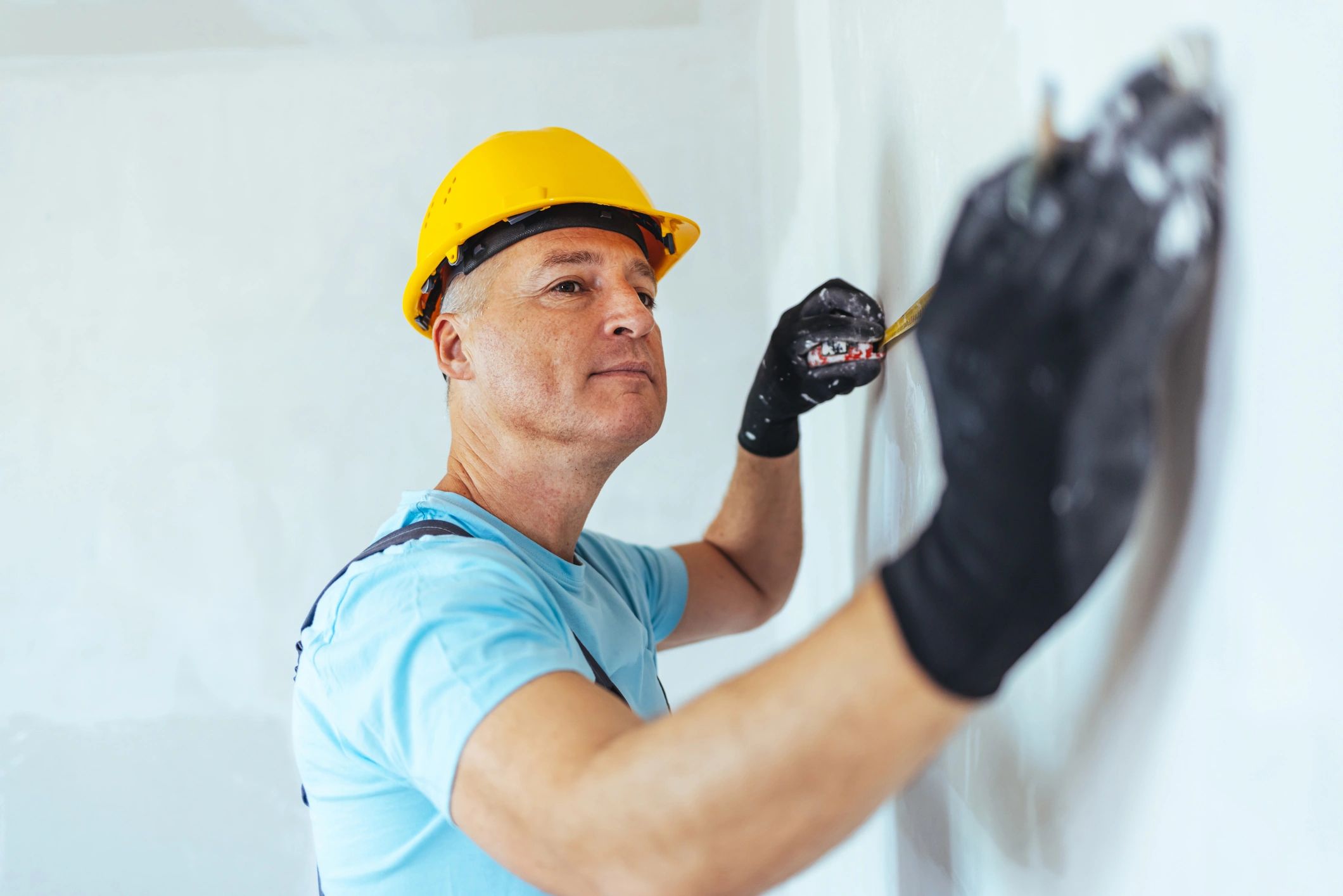 Construction Worker With Tape Measure On Site