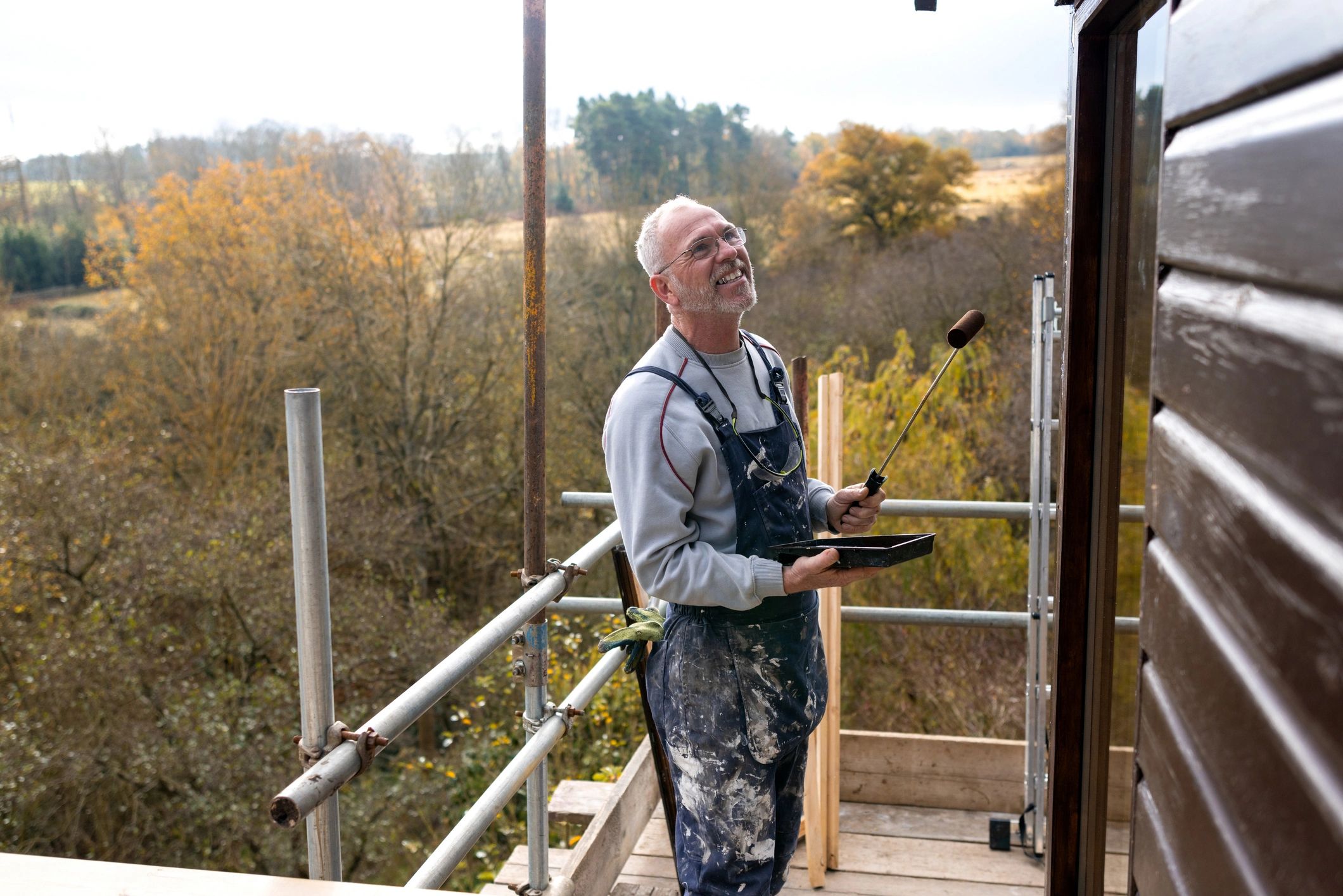 Handyman painting a wall with a roller