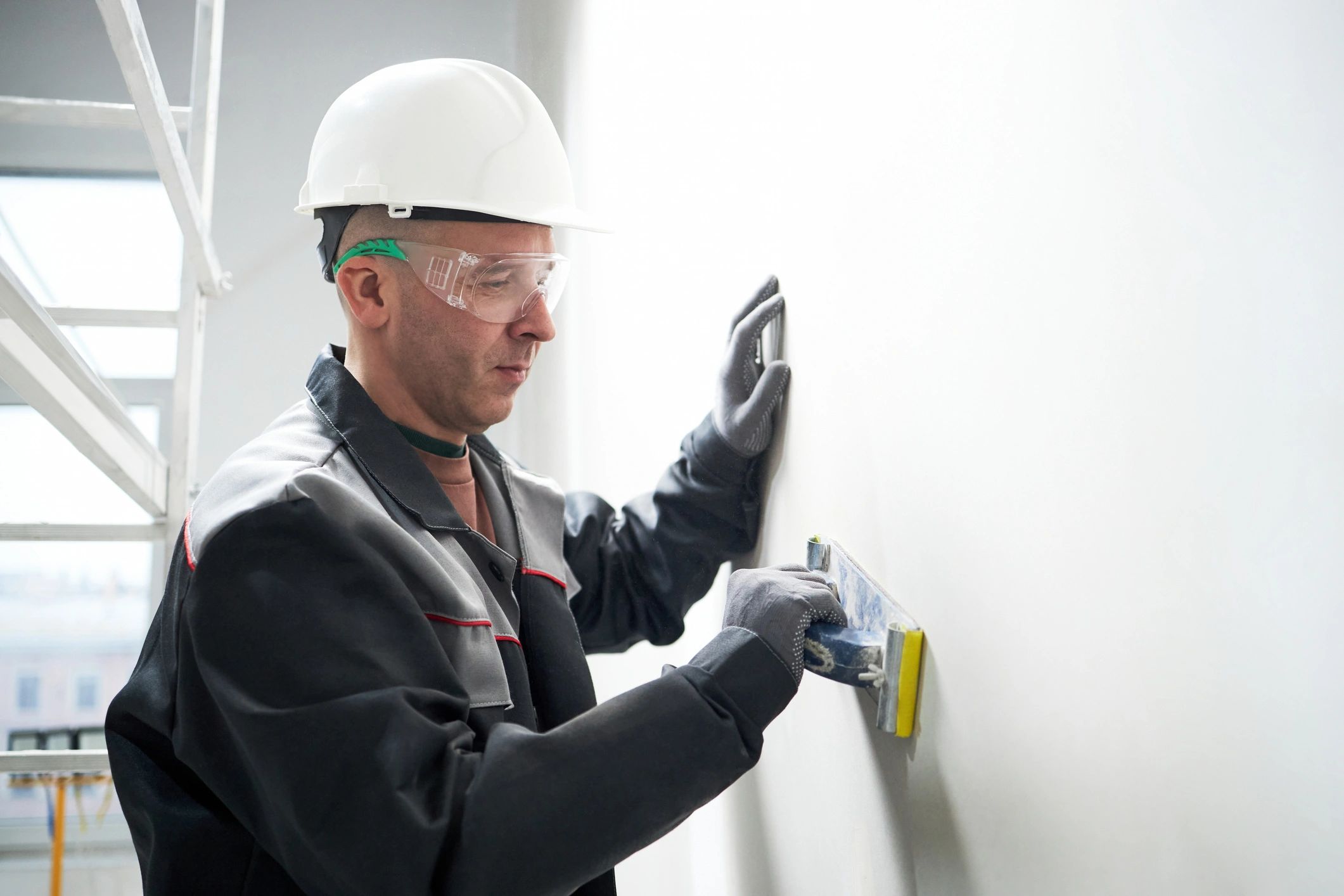 Worker applying putty to repair holes in a wall