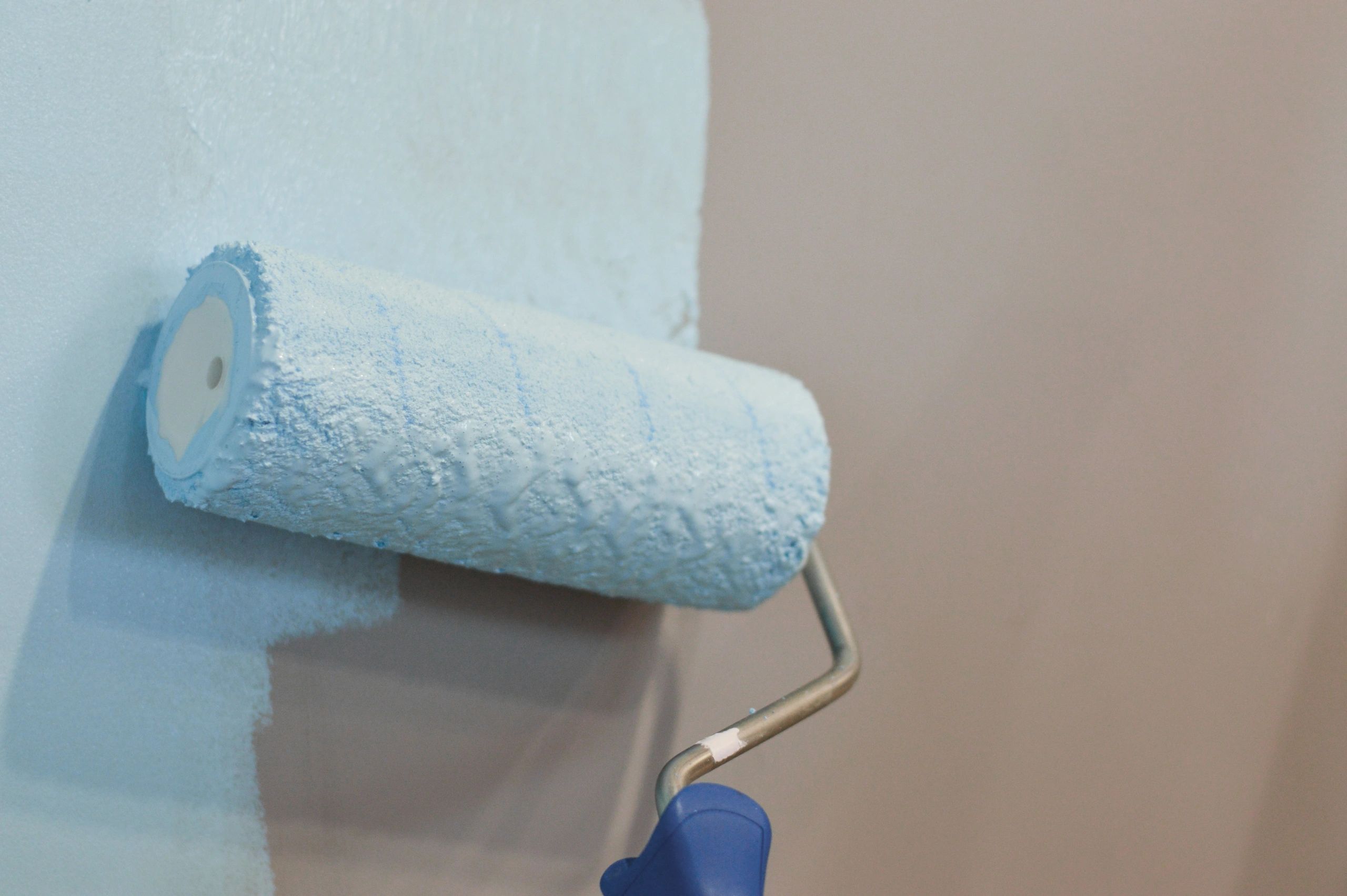 Applying paint to an interior wall with a roller