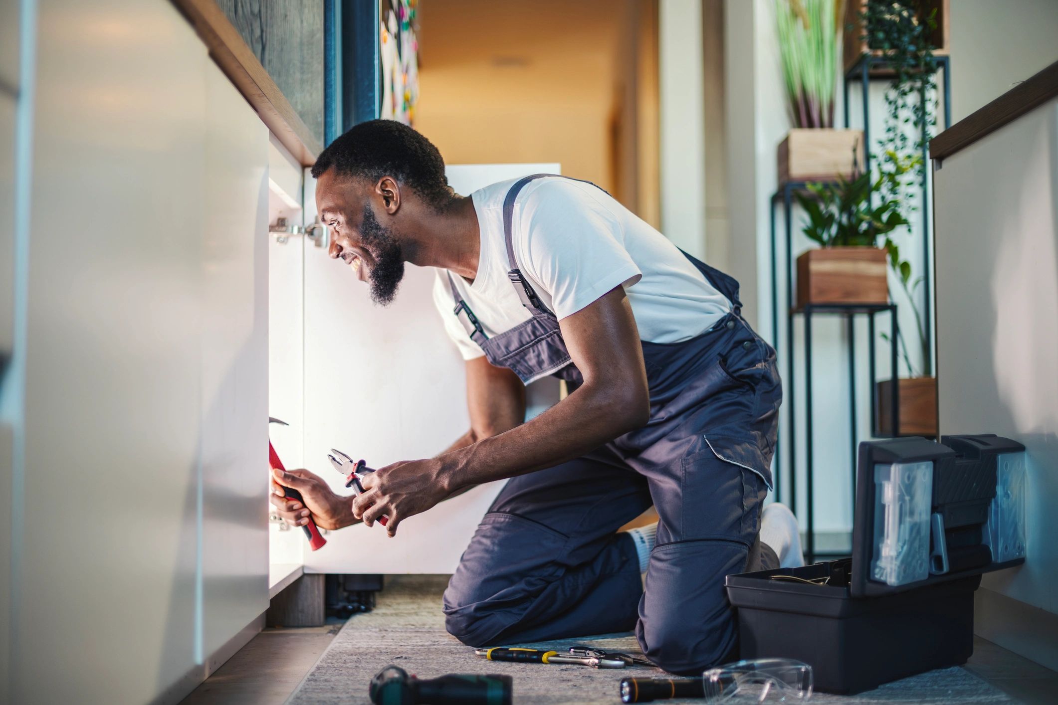 Handyman repairing a kitchen sink during a home service call